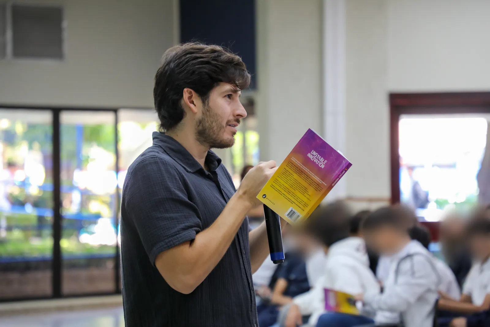Nelson Inno leyendo Innovación Inestable frente a un grupo de estudiantes de colegio en El Salvador